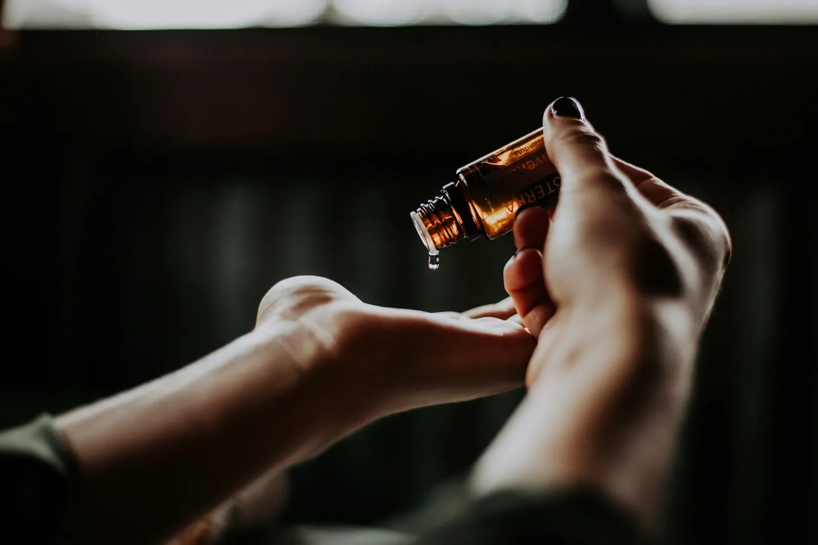 Aceite esencial cayendo sobre la mano